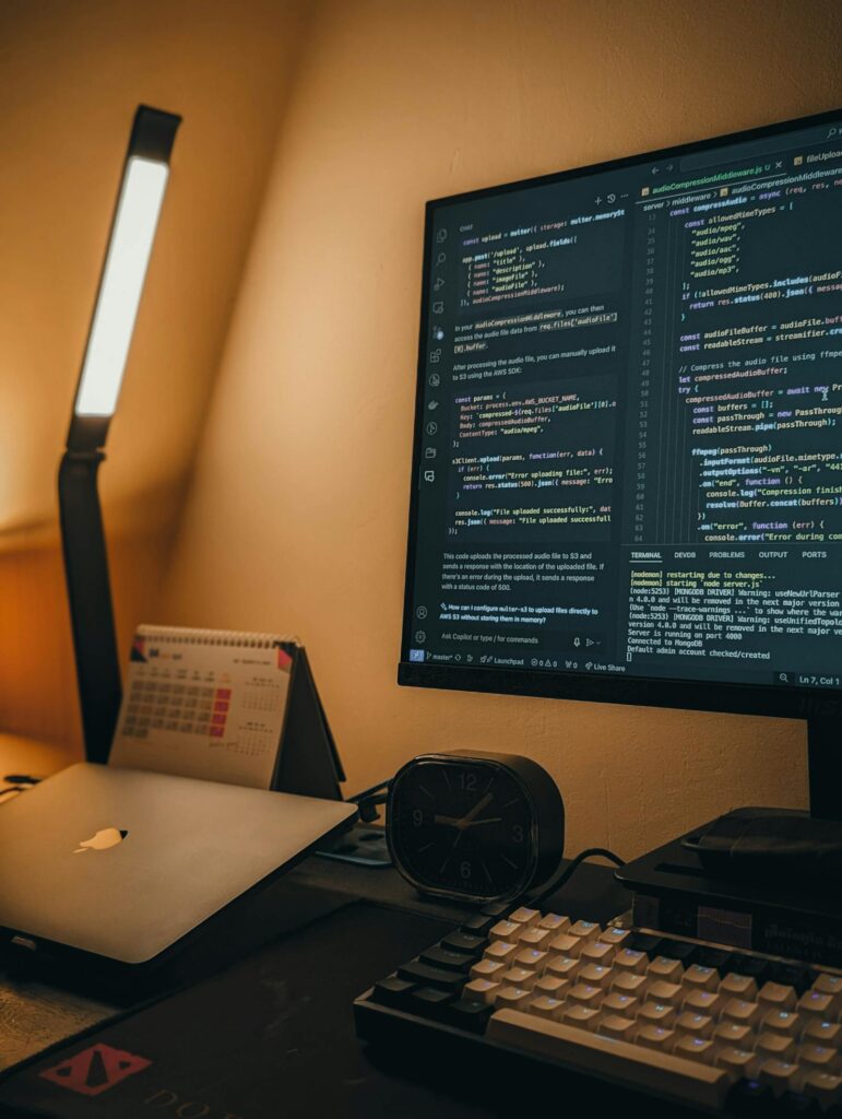 Coding monitor and laptop setup representing payment API infrastructure